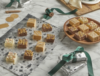 An assortment of fudge sitting on a sheet of aluminum foil next to wrapped packages