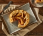 Apple and cranberry tart sitting on a parchment lined baking sheet