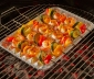 Shrimp and vegetable skewers sitting on top of a grill pan on a charcoal grill