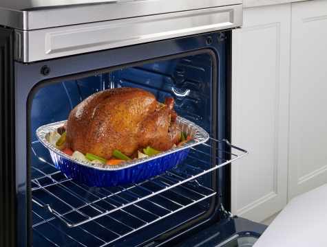 Turkey in a disposable roasting pan sitting in an oven