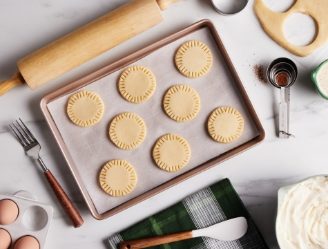 Mini pie doughs sitting on a parchment lined baking sheet