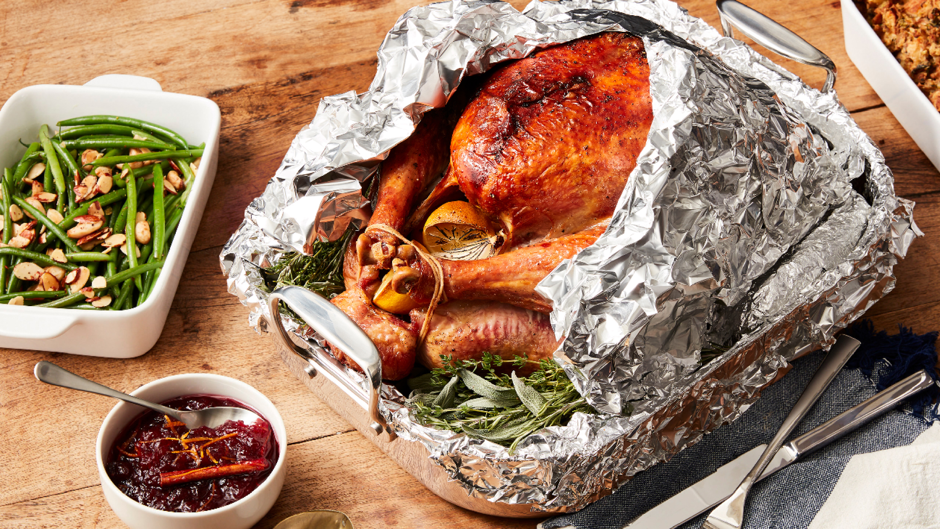 Turkey wrapped in foil with side of green beans and cranberry sauce